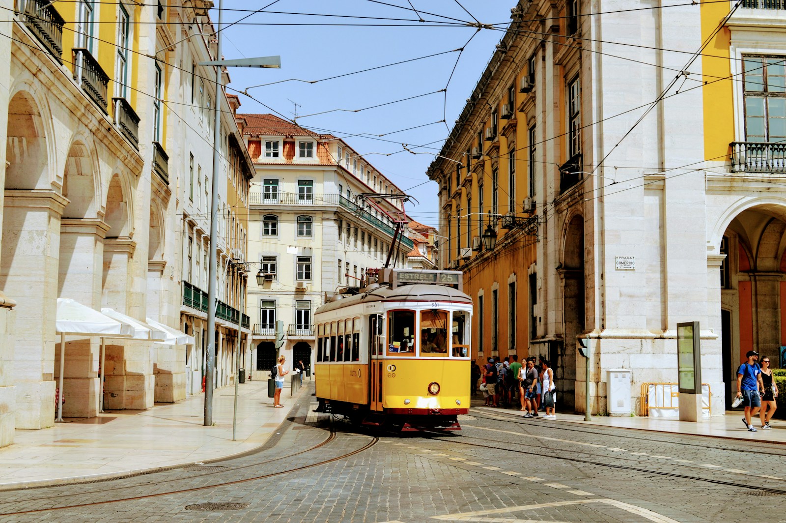 A yellow tram between historic buildings in Lisbon